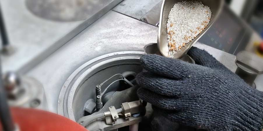 A very skilled Thai employee at Phoenix Manufacturing poring pure the combination of pure silver and alloy (a combination for sterling silver) into the casting machine